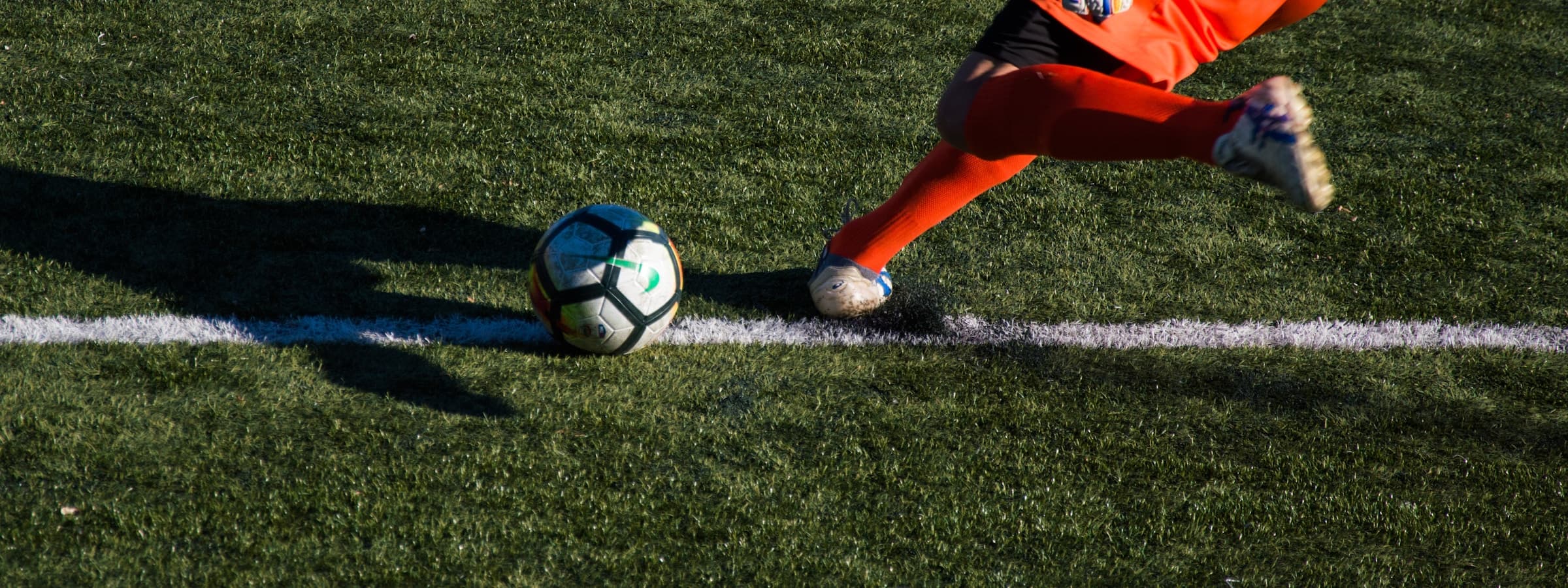 A player striking the ball on the touchline